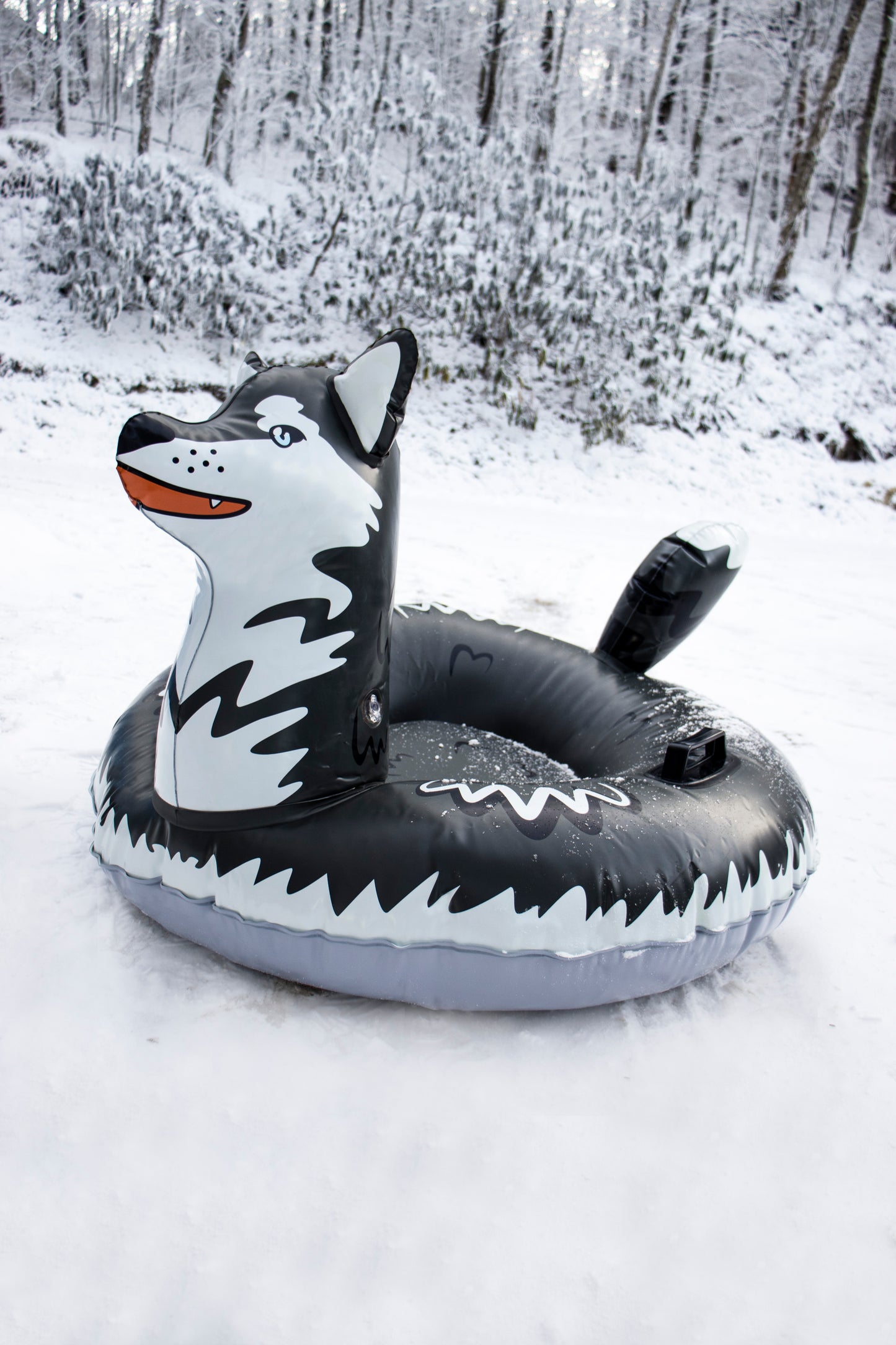 Inflatable wolf pool toy on a snowy ground with trees in the background